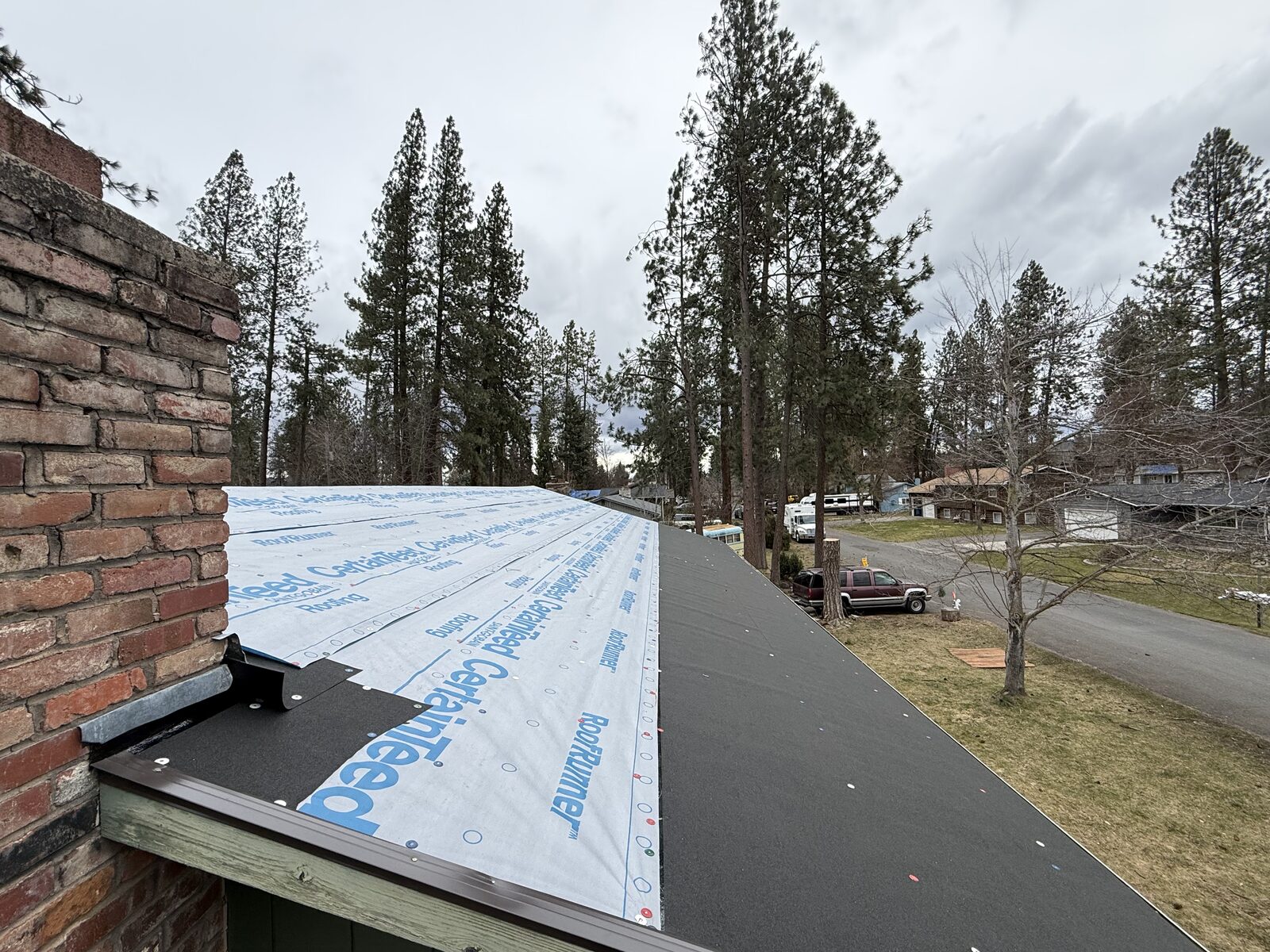 Close-up of a North Idaho roof showing the wrong fastener used on the underlayment, a common warranty-voiding installation mistake