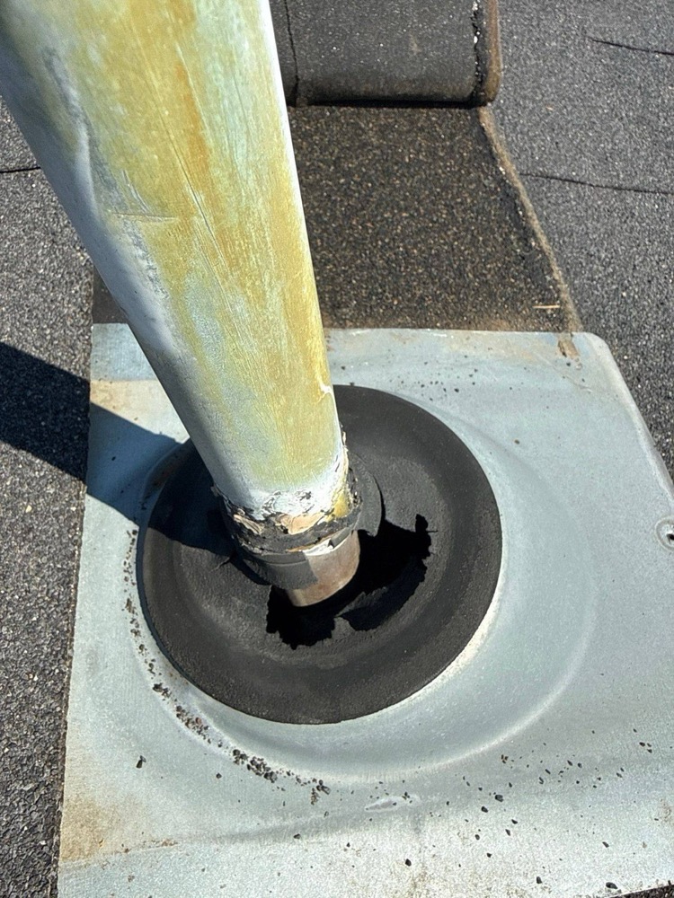 Pipe jack on a North Idaho roof with its rubber seal deteriorated and torn away from the vent pipe, leaving an open gap into the roof