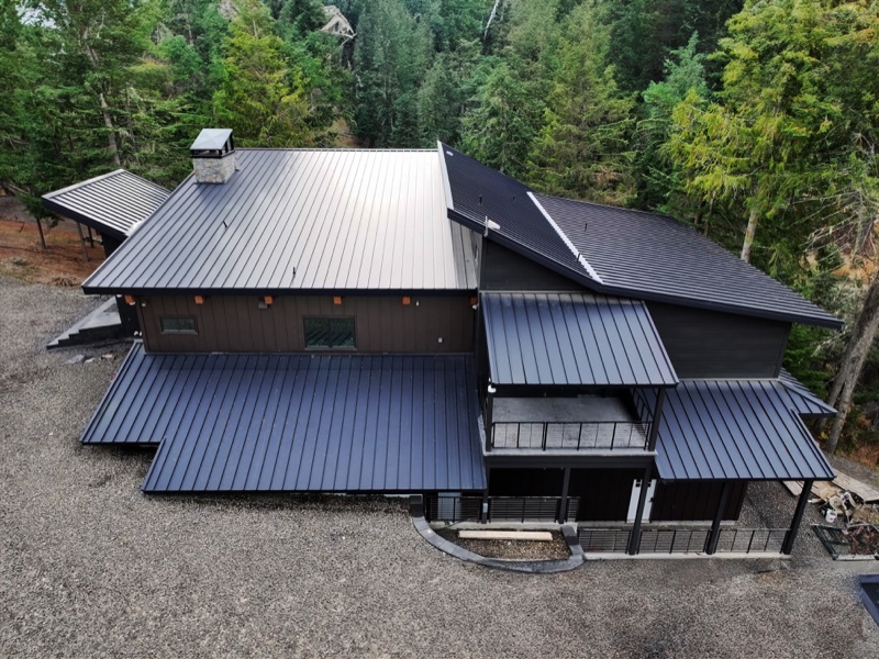 A black standing seam metal roof on a North Idaho home, seen from above