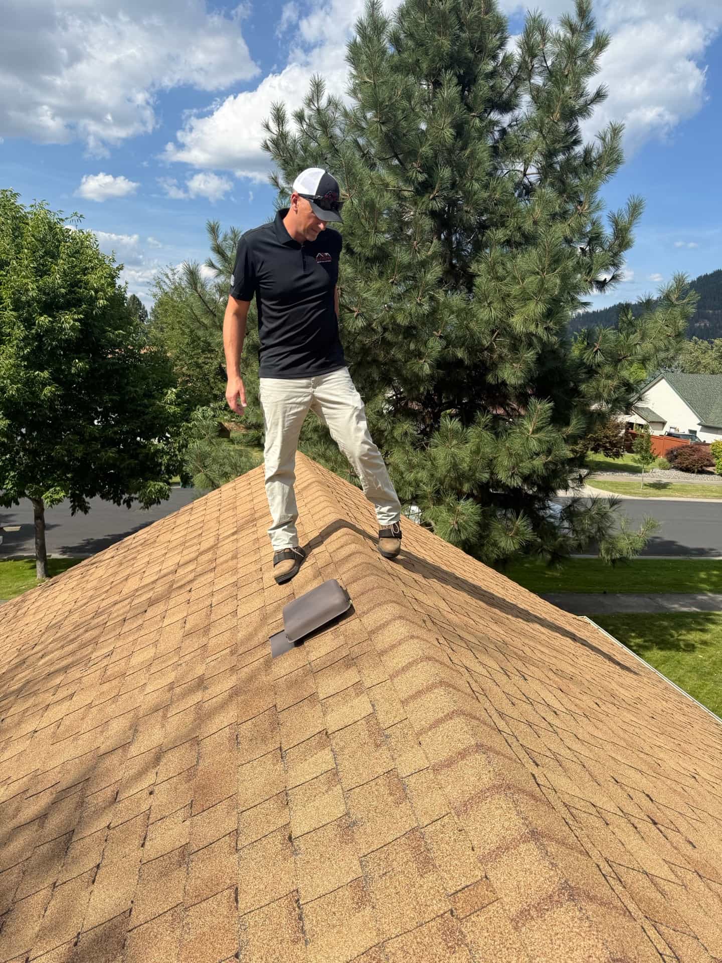 Roofer inspecting a residential roof in North Idaho