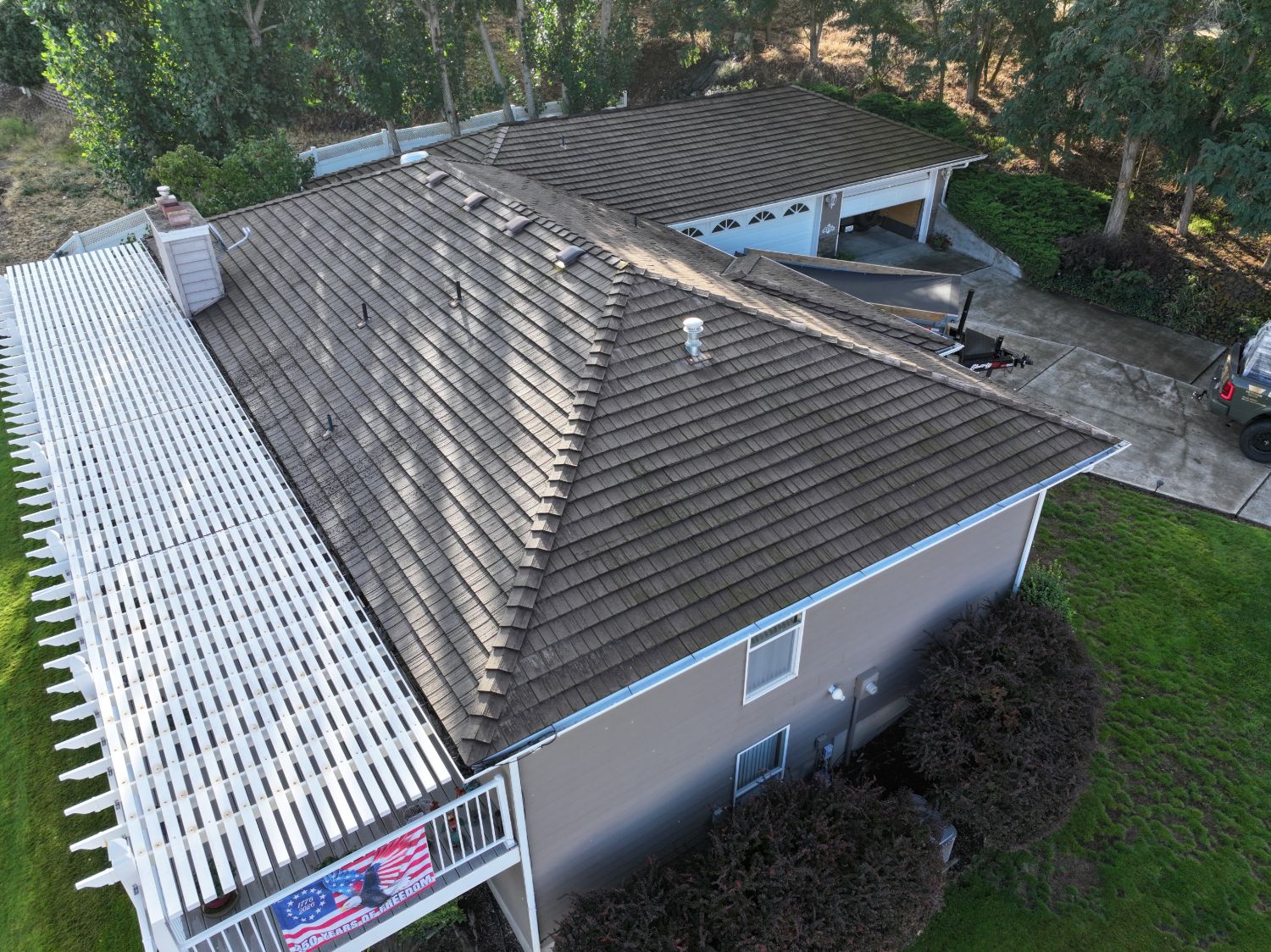 Before: hip end of the old roof over the deck with moss and staining on the tiles