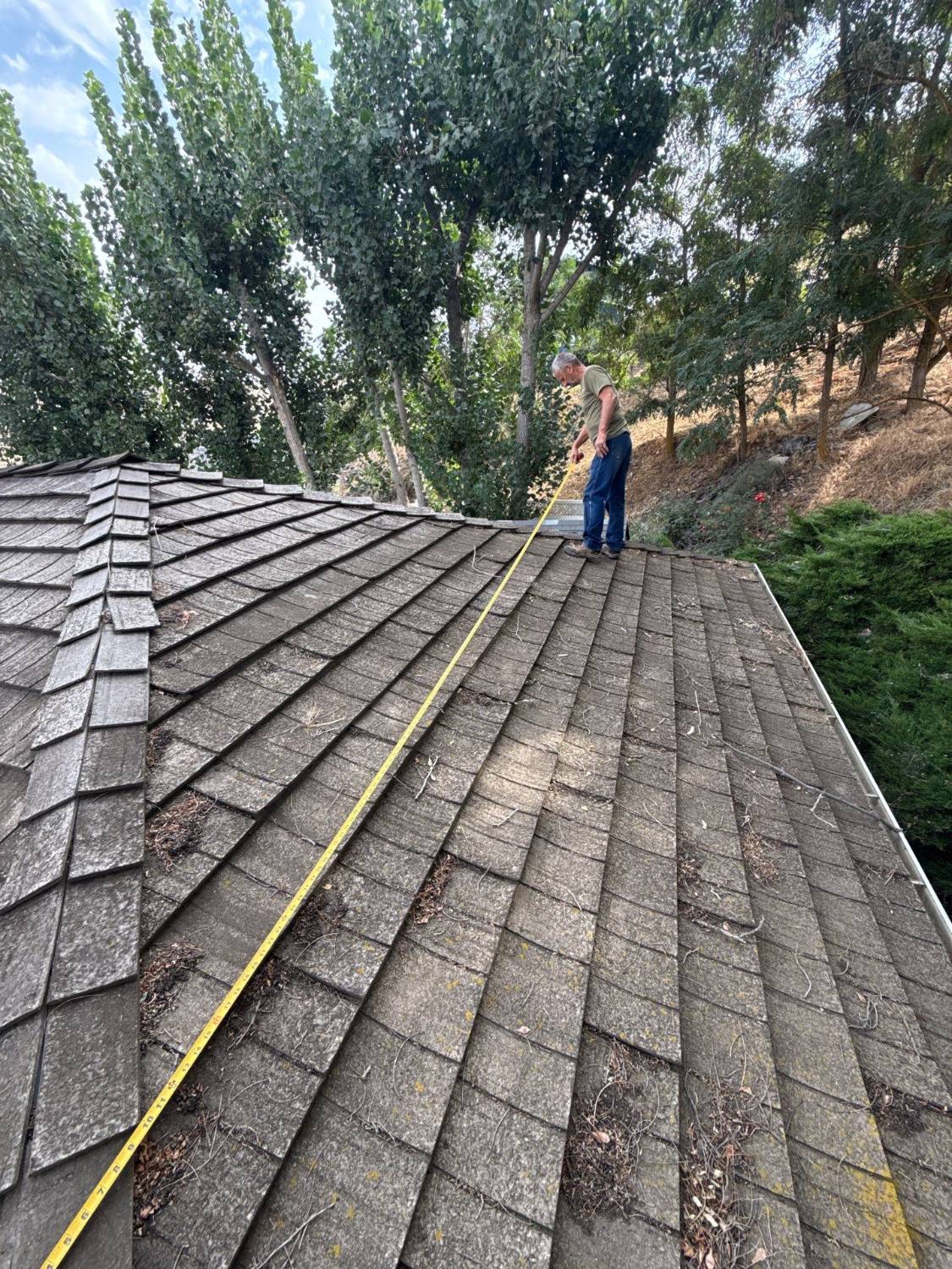 Before: measuring the old roof, with debris and moss built up between the shakes