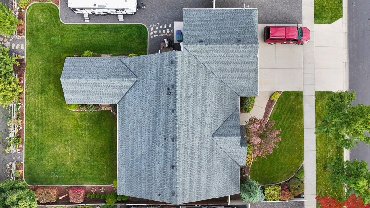 Top-down aerial view of completed Granite Gray roof showing full layout with vehicles on street