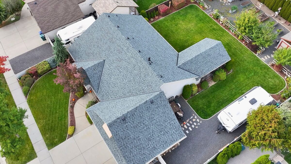 Aerial angled view of completed Granite Gray roof with neighboring homes visible
