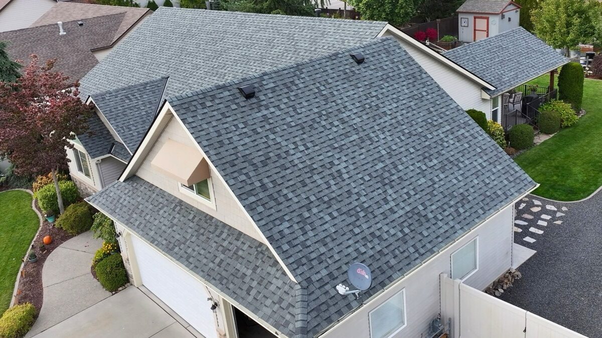 Aerial side view of completed roof showing garage gable and clean shingle lines