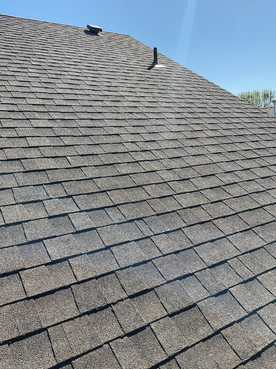 Side view of aging roof showing widespread granule loss across shingle surface