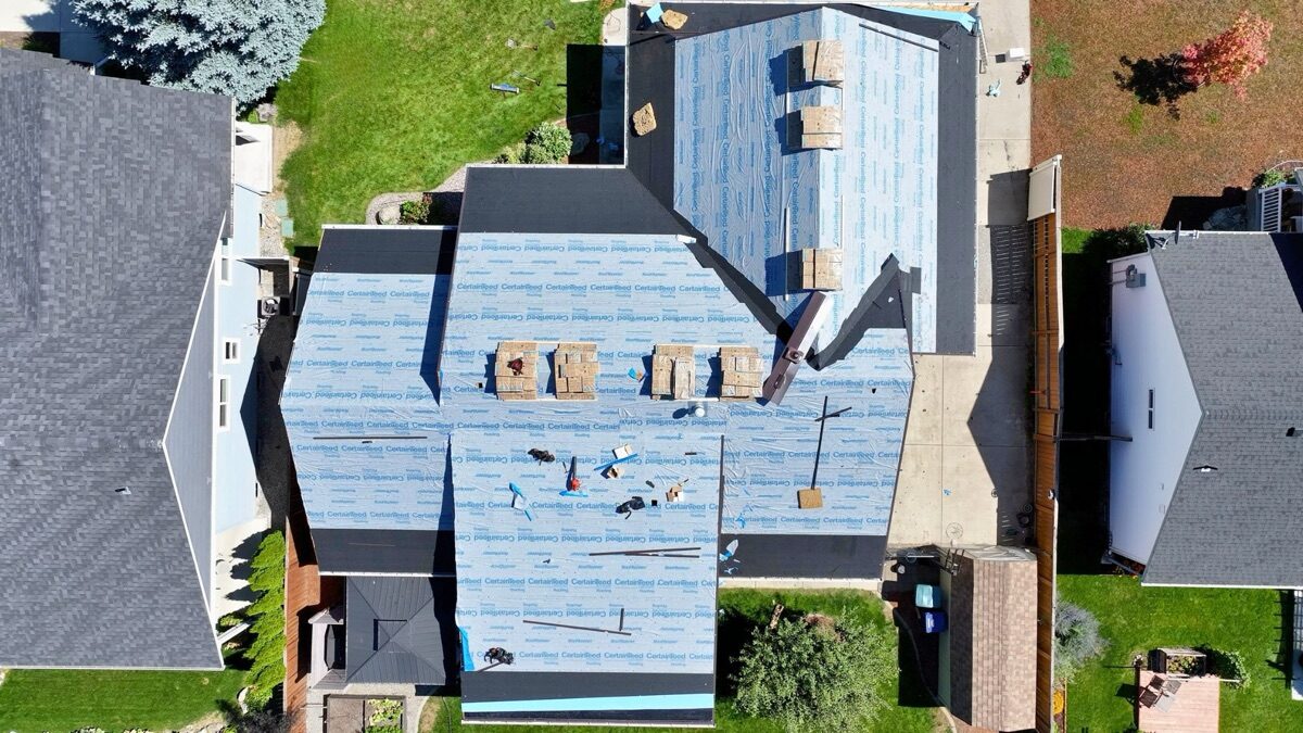 Before: aerial view of roof during tear-off with underlayment installed
