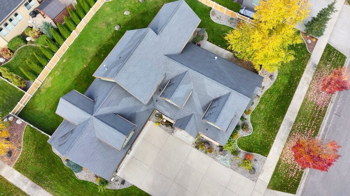 Top-down aerial of old faded roof with fall foliage