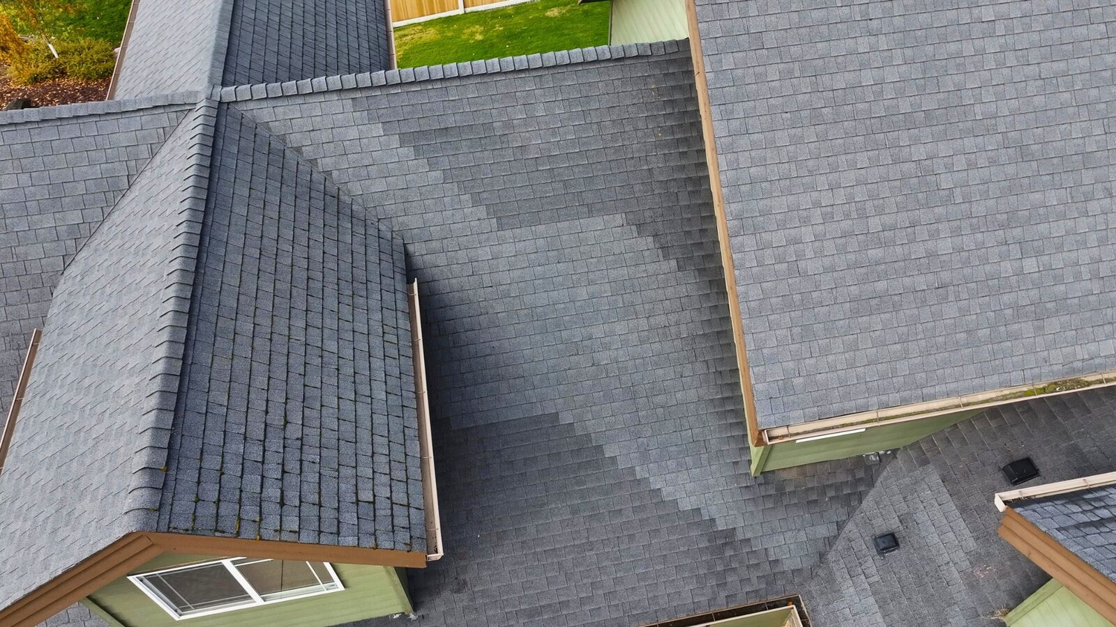 Close-up aerial showing weathered shingles at roof valleys