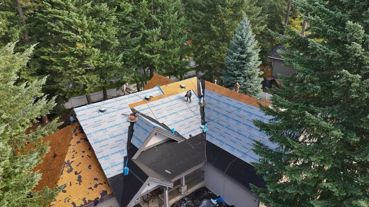 Aerial of crew installing CertainTeed synthetic underlayment on replaced decking