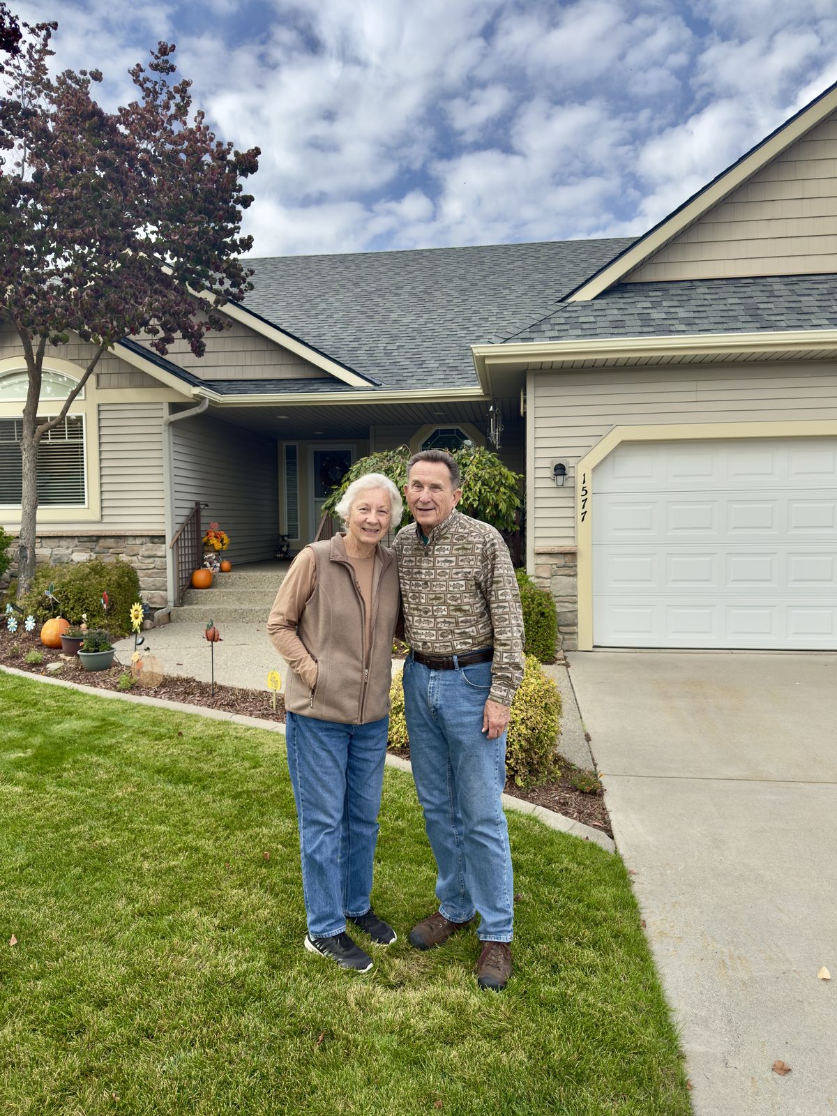 Homeowners standing in front of their home with the new Granite Gray roof