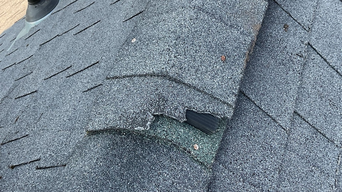 Close-up of cracked shingle at the ridge