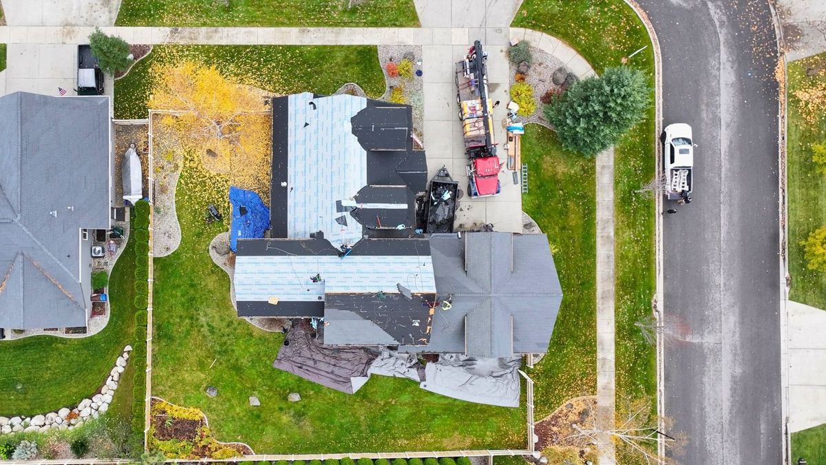 Top-down aerial mid-replacement — new shingles partially installed