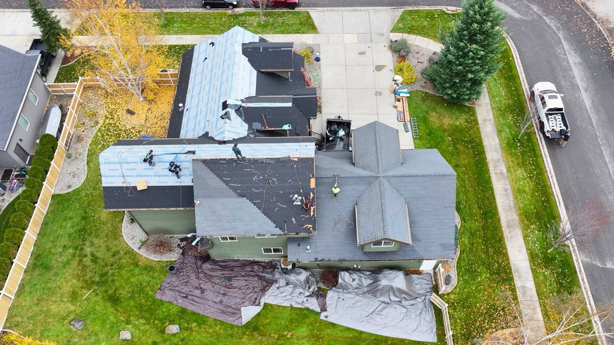 Aerial view showing new shingles going on with underlayment visible